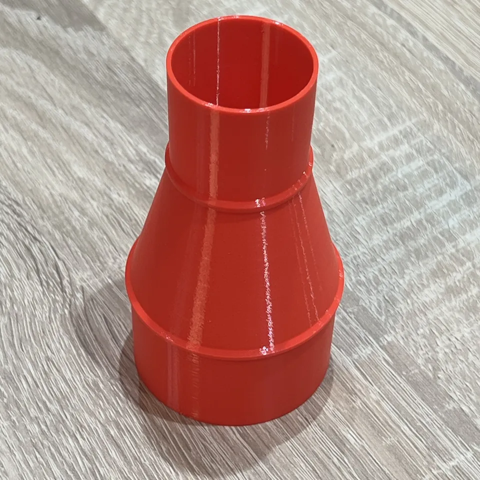 Dust collection adapter - Upright red adapter showing the smaller opening and printed surface